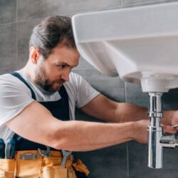 focused-male-plumber-in-working-overall-fixing-sink-in-bathroom-1536x1025